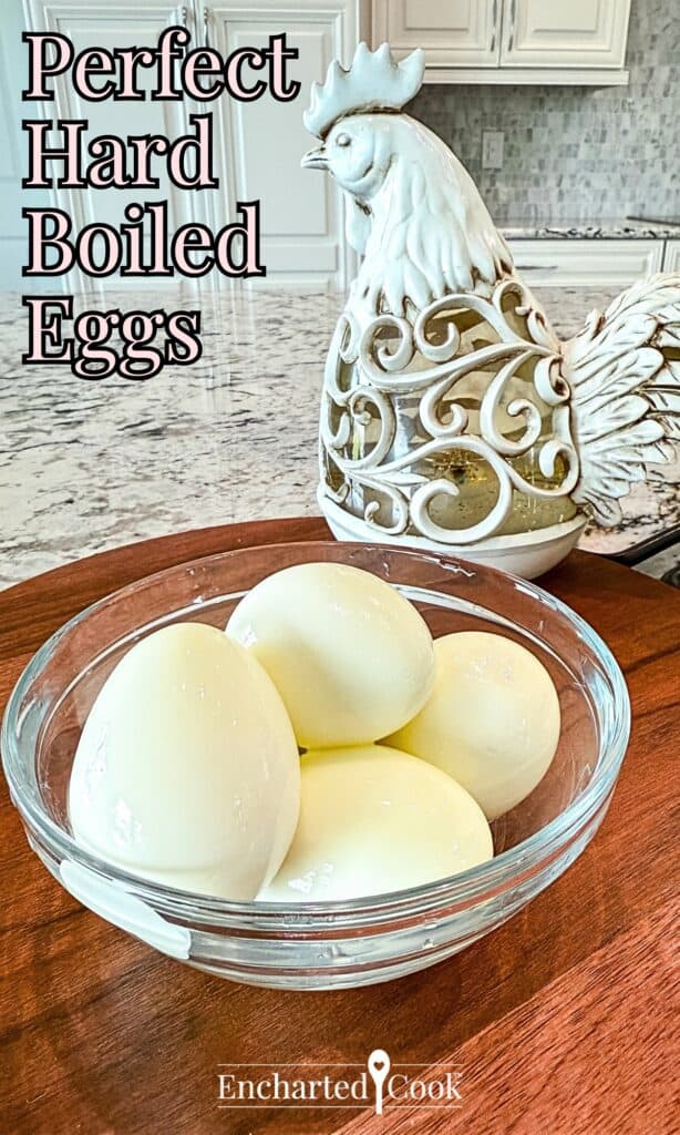 Perfect hard boiled eggs with the eggshell removed and are in a glass bowl with text overlays.