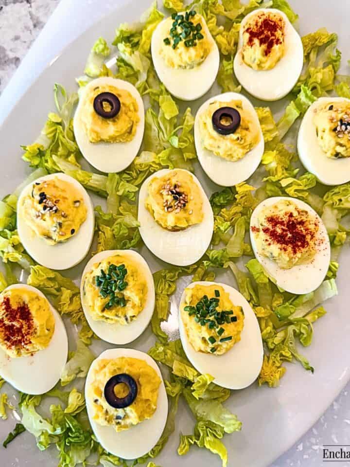 Deviled Eggs with various garnishes on a white platter with lettuce.