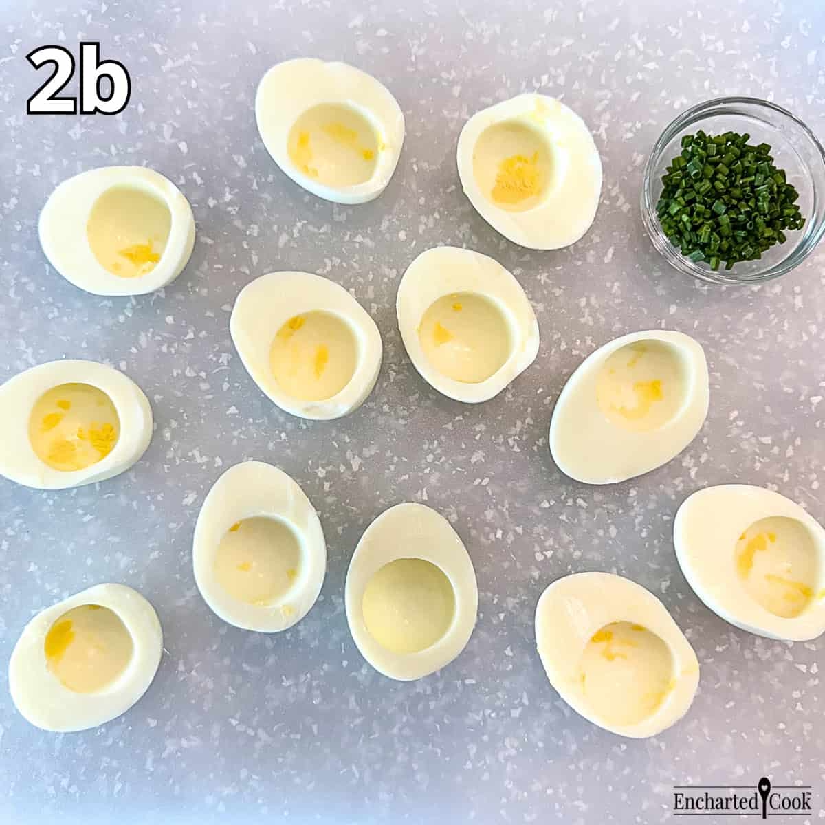 Process Photo 2b - The halved eggs without their yolks on a cutting board.