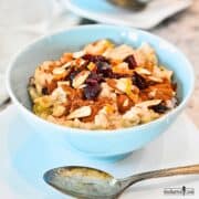Creamy Good Morning Oatmeal in a blue bowl topped with cinnamon, dried cranberries, and sliced almonds.