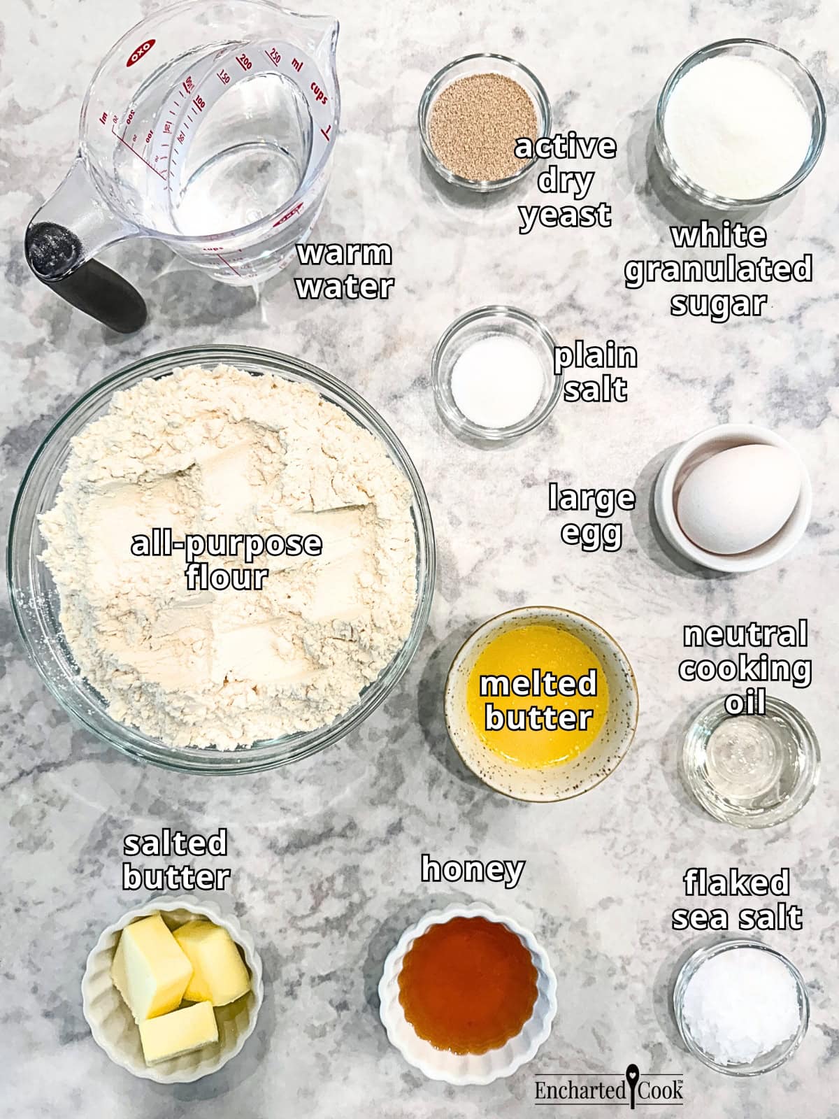 Steakhouse Dinner Roll ingredients, clockwise from top left: warm water, dry active yeast, white granulated sugar, plain salt, large egg, melted butter, neutral cooking oil, flaked sea salt, honey, salted butter, and all-purpose flour.