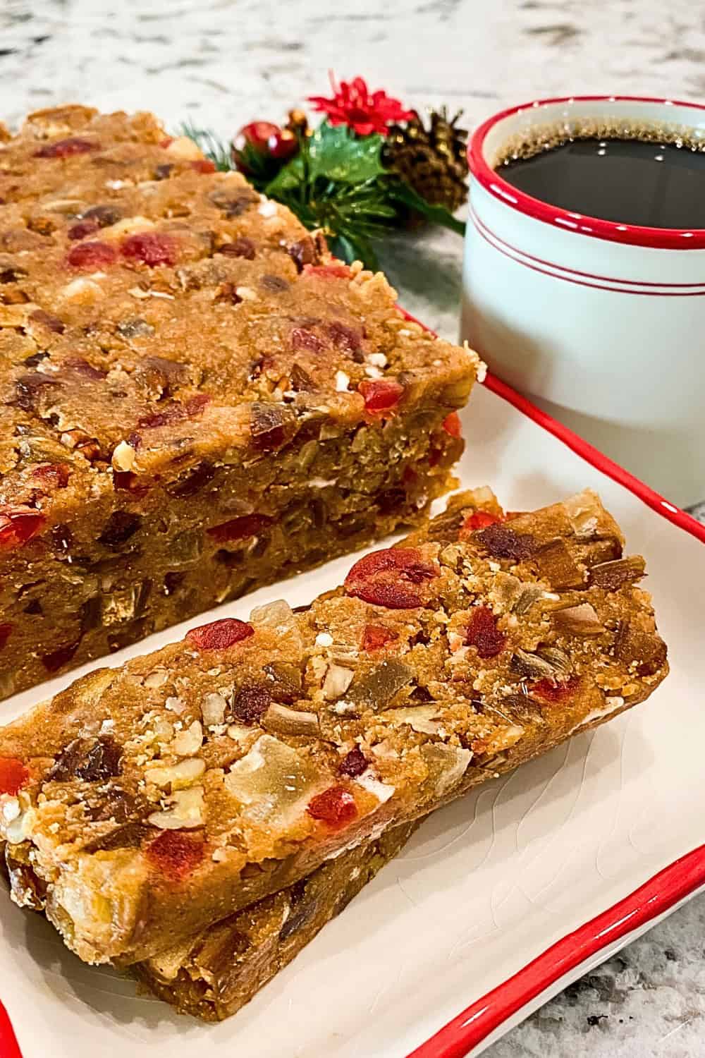 Sliced loaf of No-Bake Biscoff Fruitcake on a platter with a cup of black coffee.