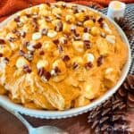 Pumpkin Spice Fluff in a white bowl surrounded with autumn decorations.