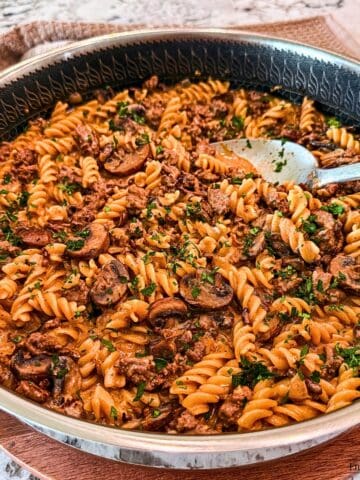 Ground Beef Stroganoff in a large pan with a spoon.