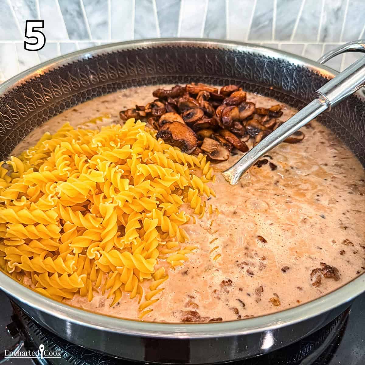Process Photo 5 - Adding rotini pasta and the cooked mushrooms to the skillet.