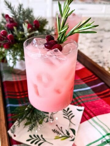 Cranberry Pink Drink garnished with cranberries and rosemary.