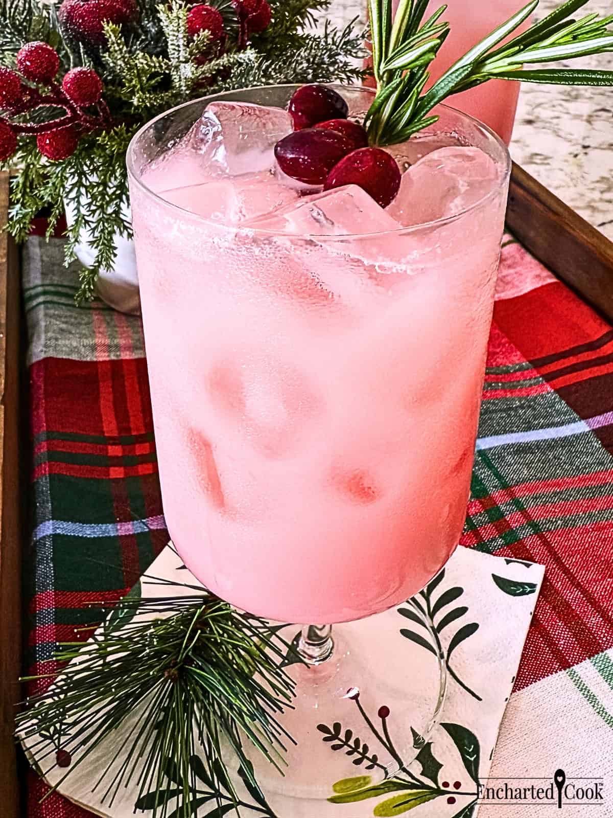 Cranberry Pink Drink garnished with cranberries and rosemary.