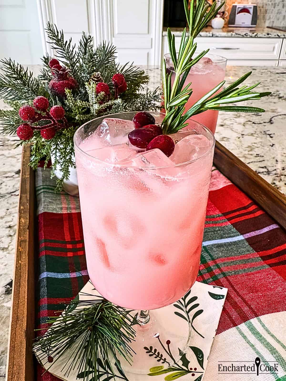 Cranberry Pink Drink garnished with cranberries and rosemary.