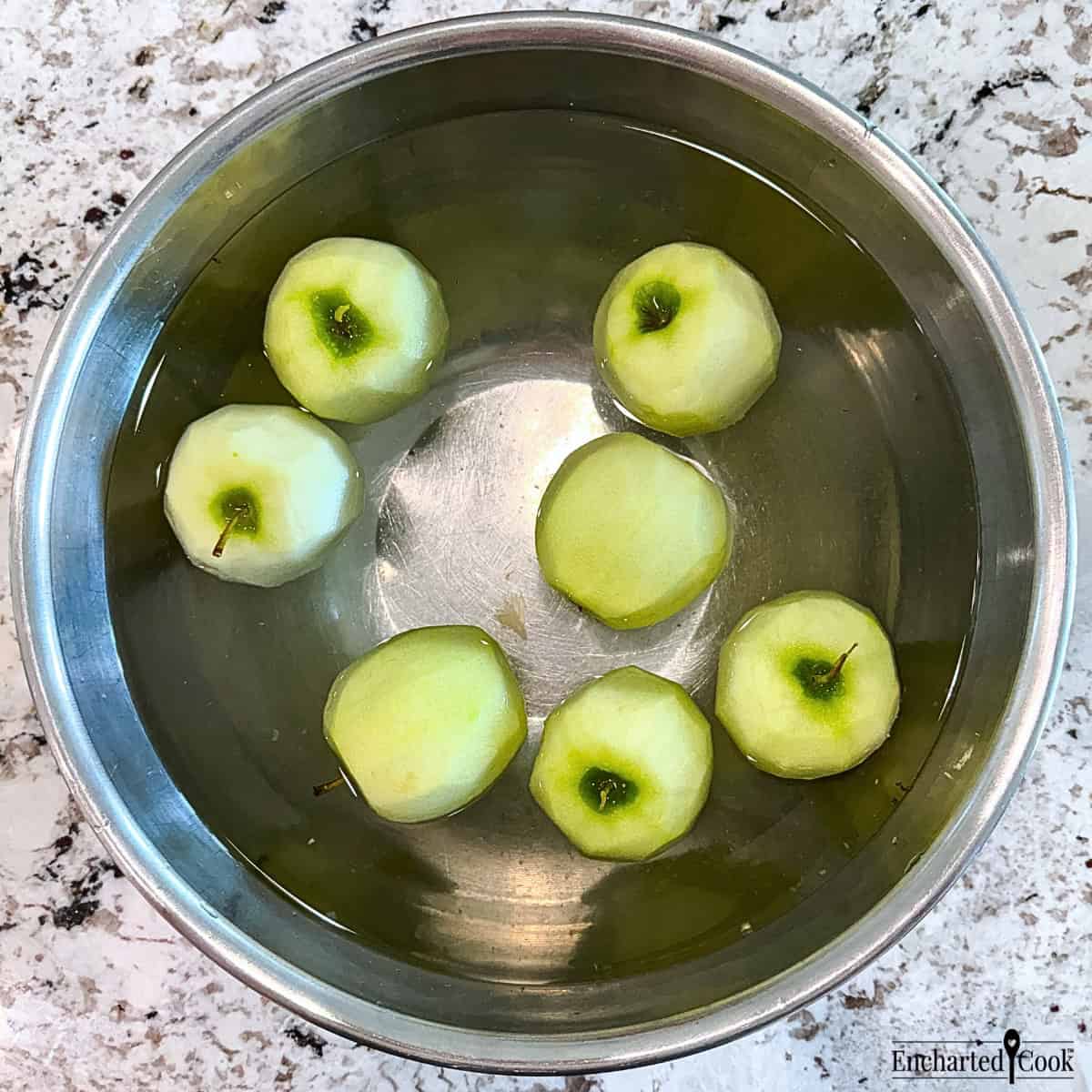 Peeled Granny Smith apples in a large bowl of water with lemon juice to keep them from turning brown.