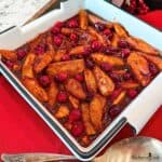 Southern Fried Apples and Cranberries in a white dish with a spoon.