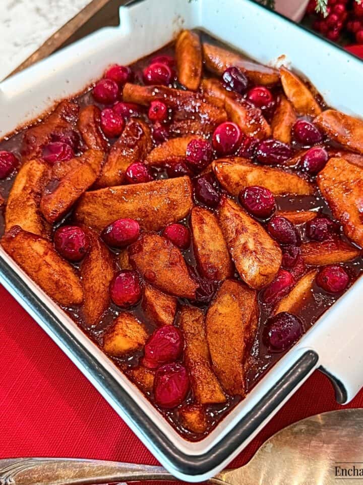 Southern Fried Apples and Cranberries in a white dish with a spoon.