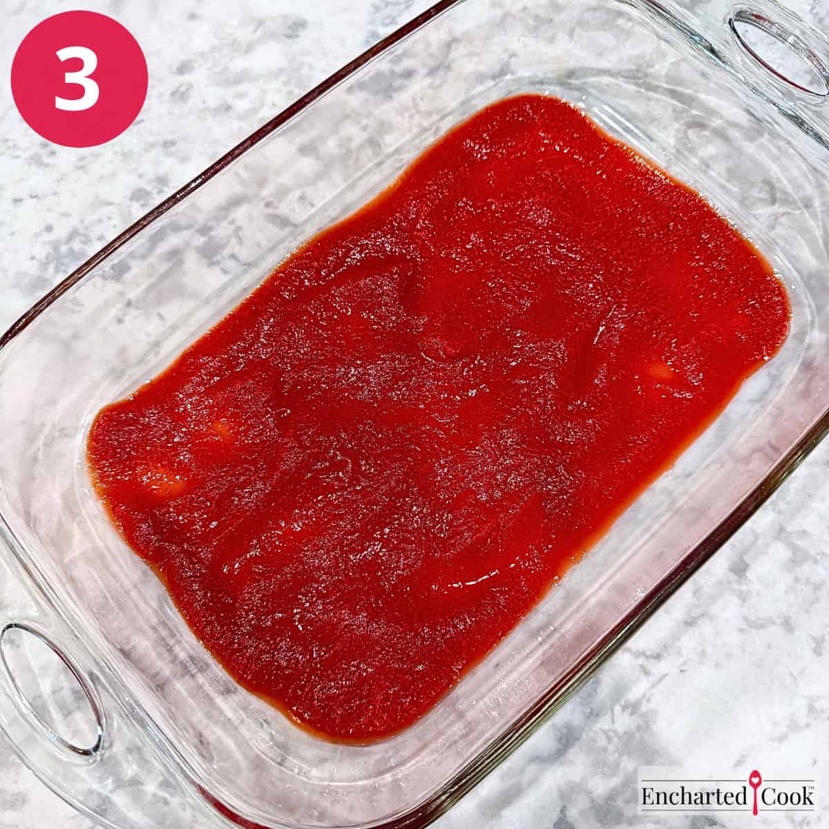 Process Photo 3 - A thin layer of enchilada sauce is spread across the bottom of the 13x9" baking dish.