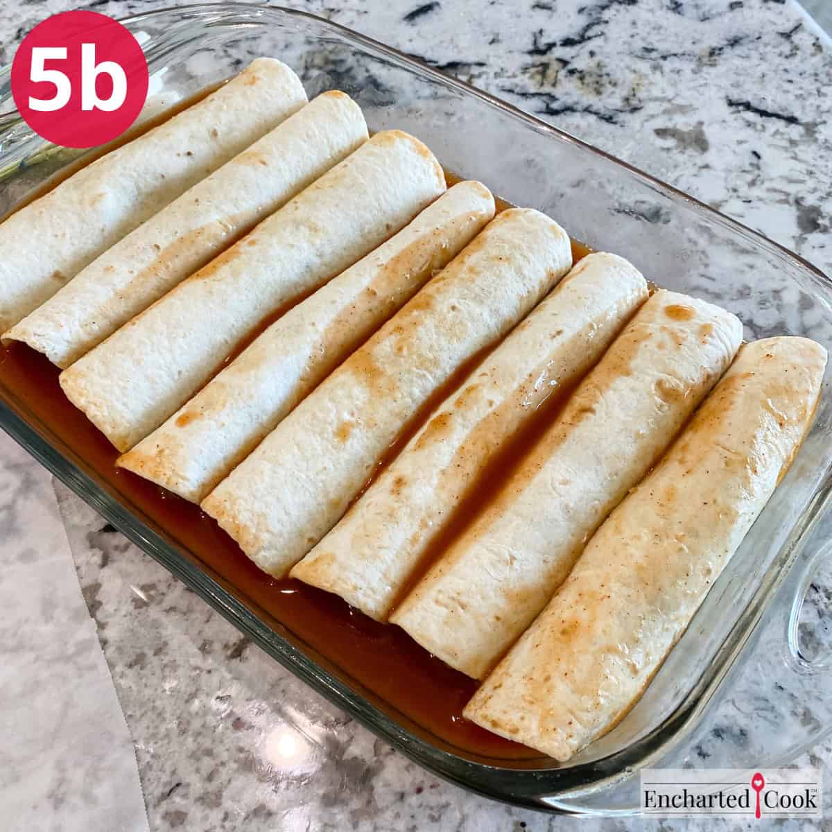Process Photo 5b - Placing the rolled enchiladas in a sauce lined baking dish.