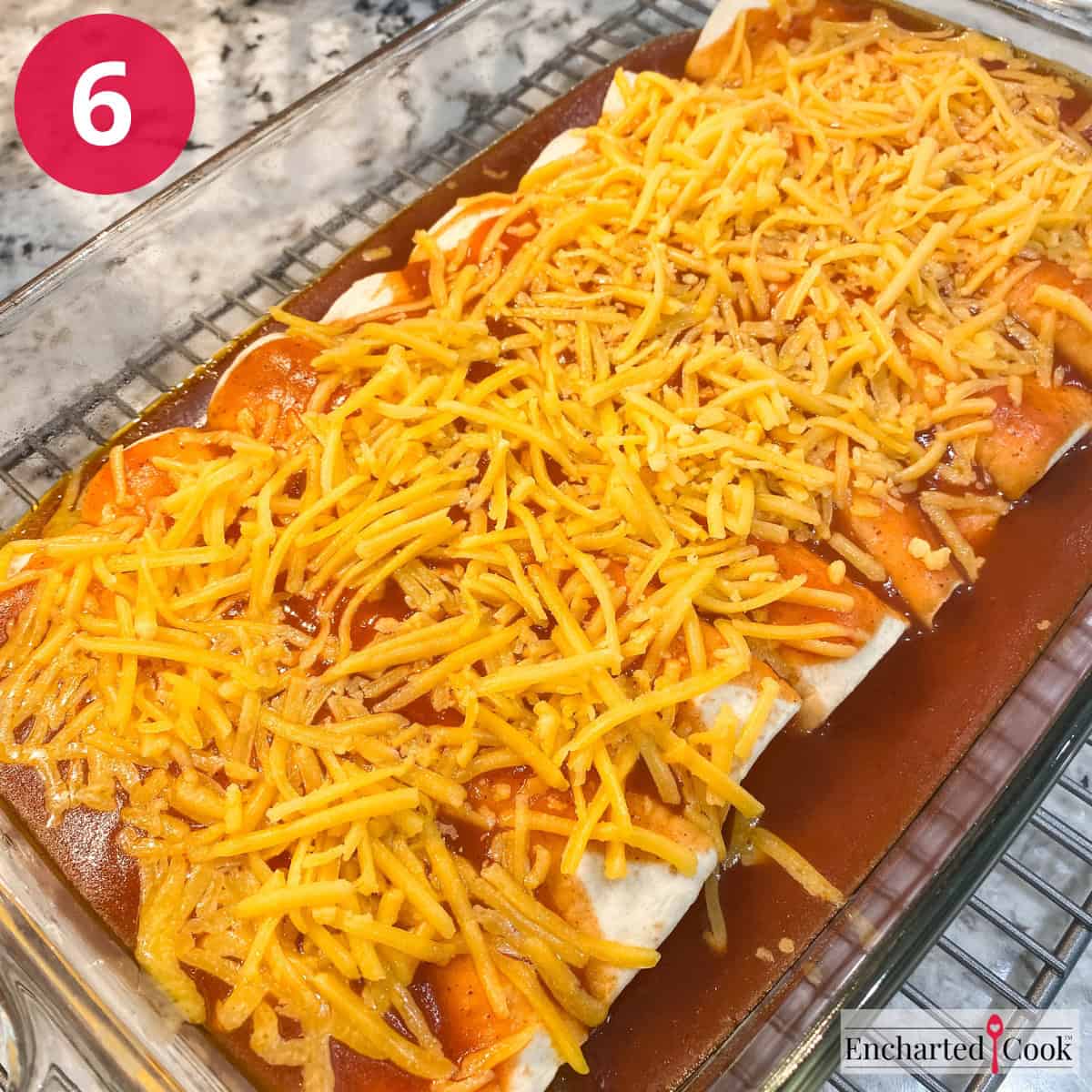 Process Photo 6 - The enchiladas are topped with sauce and cheese and are ready to be baked.