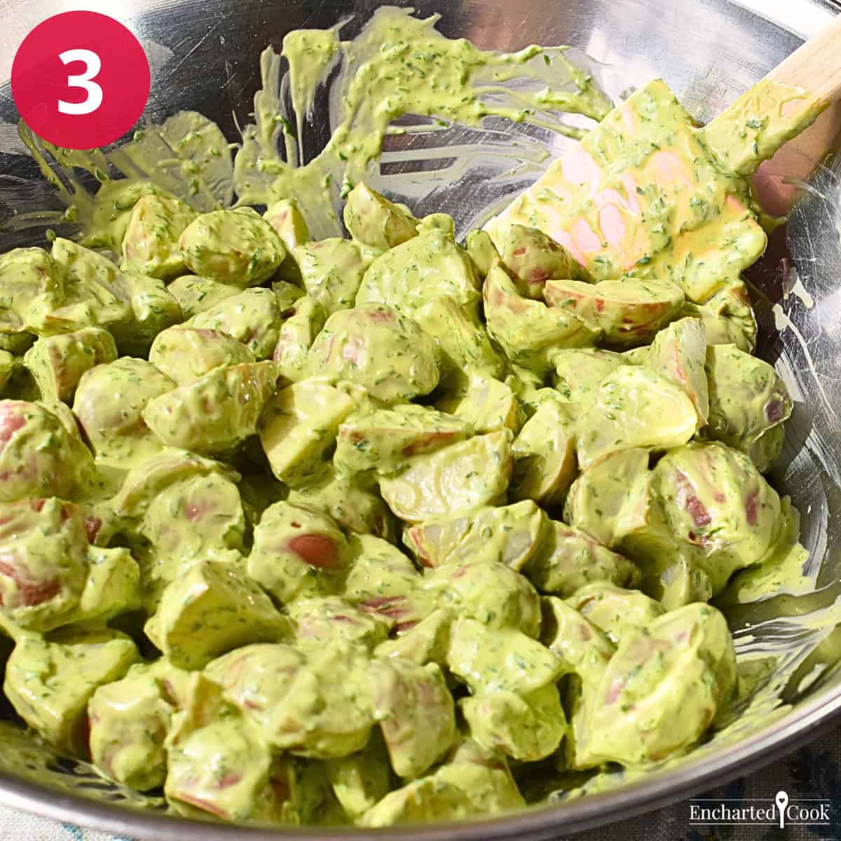 Process Photo 3 - Mixing the green goddess dressing with the cooked and cut potatoes in a large bowl.
