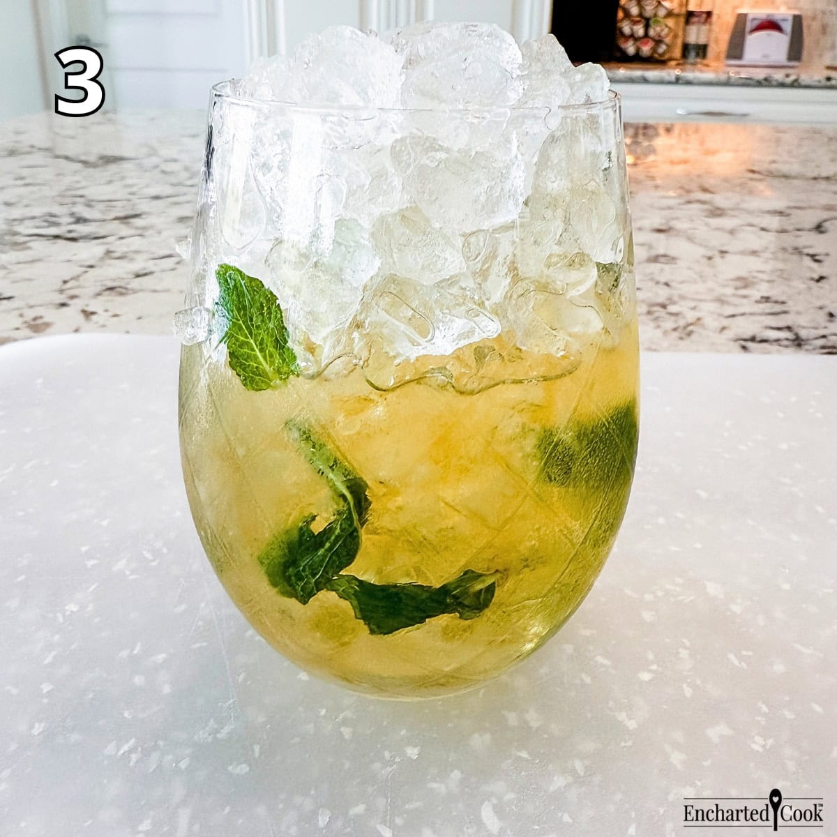 Process Photo 3 - Adding crushed ice to the glass containing the muddled mint and bourbon.