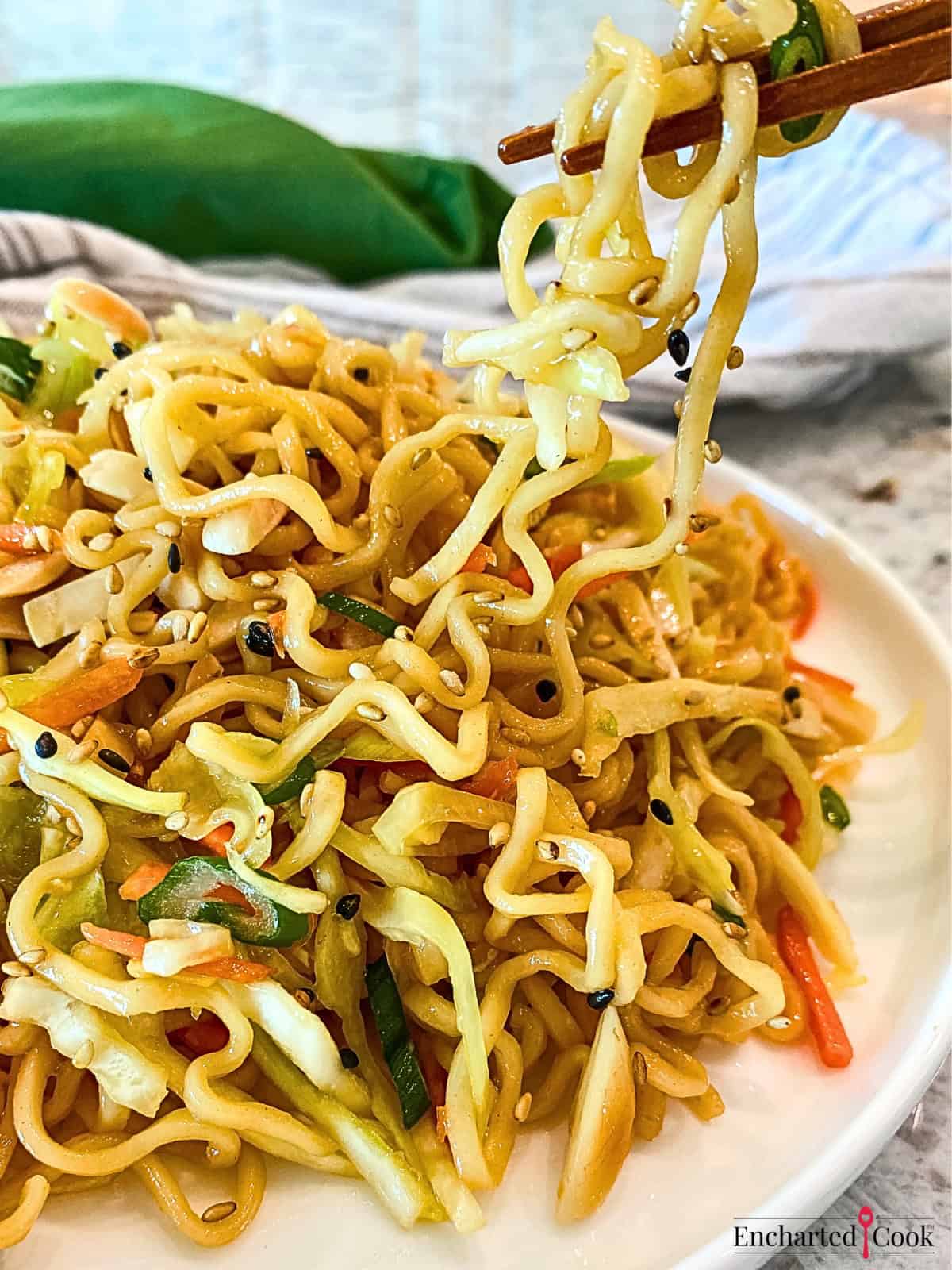 Ramen Noodle Salad in chop sticks and on a white plate.