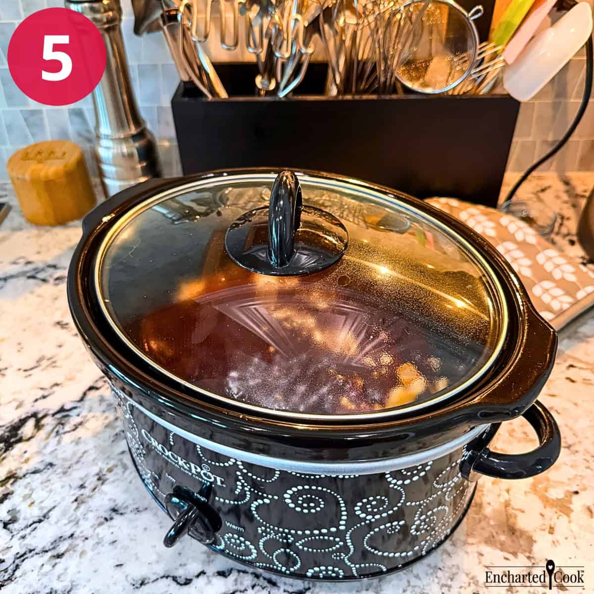 Process Photo 5: The browned chuck roast and other ingredients are in a crockpot, slow cooker, with the lid on.
