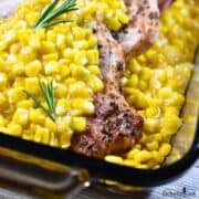 Oven Baked Pork Chops in Creamed Corn in a brown glass baking dish.