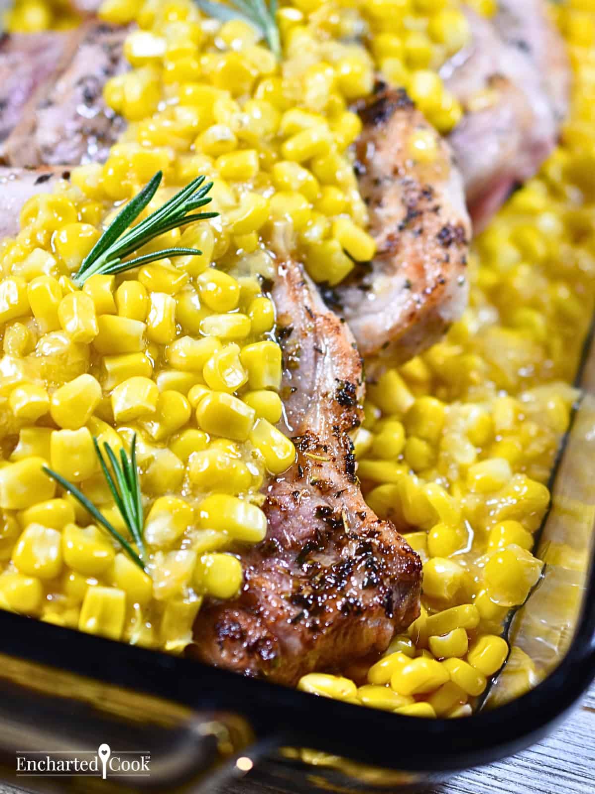 Baked Pork Chops in Creamed Corn in a brown glass baking dish.